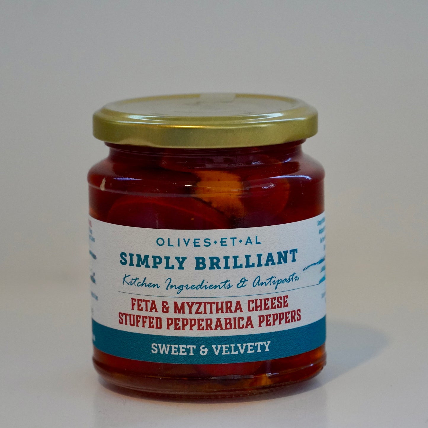 Jar of 'Simply Brilliant' feta and myzithra cheese stuffed pepperabica peppers on a white background