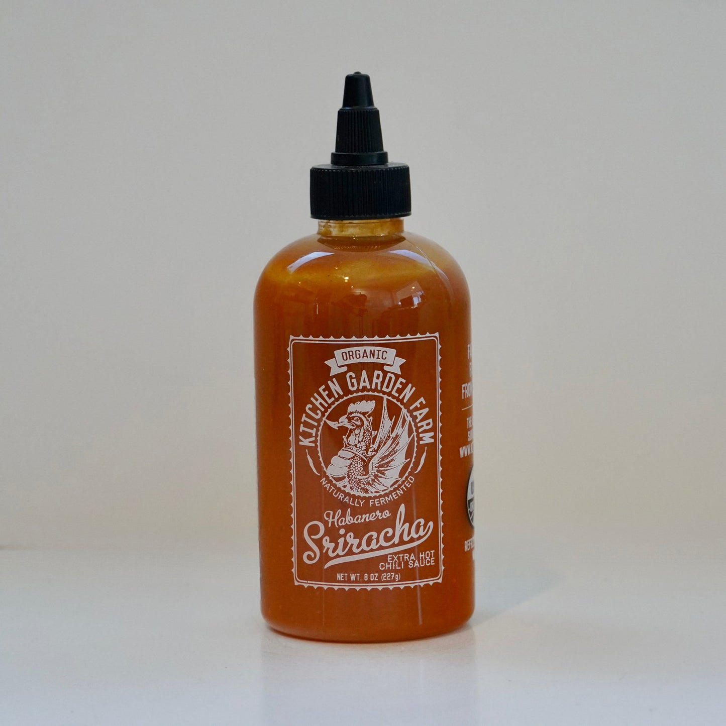 Bottle of Kettle Garden Farm Sriracha sauce on a white background