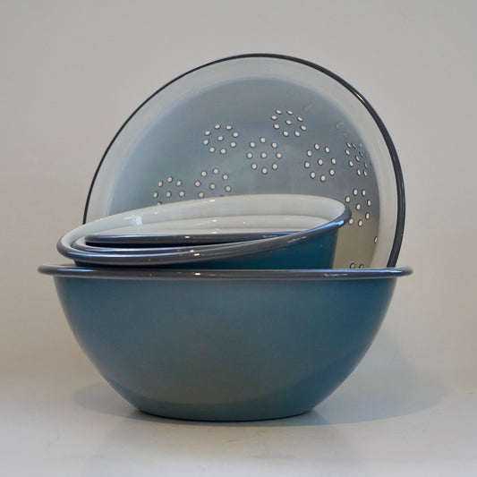 Set of blue mixing bowl and colander on a white background