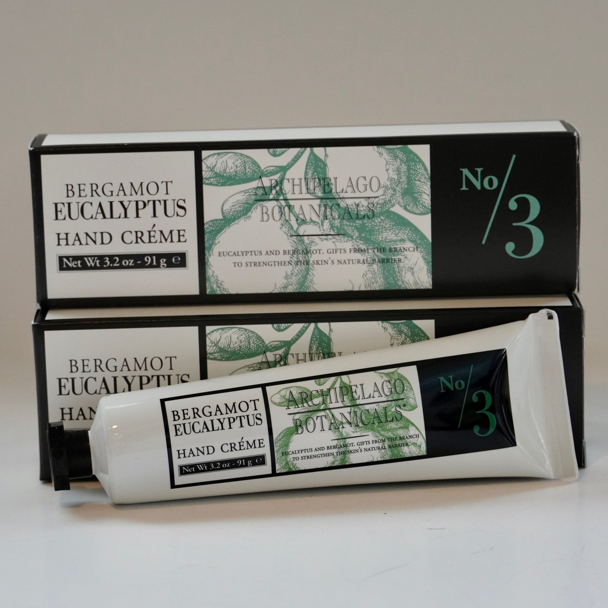 Hand cream packaging with green and white design on a light gray background