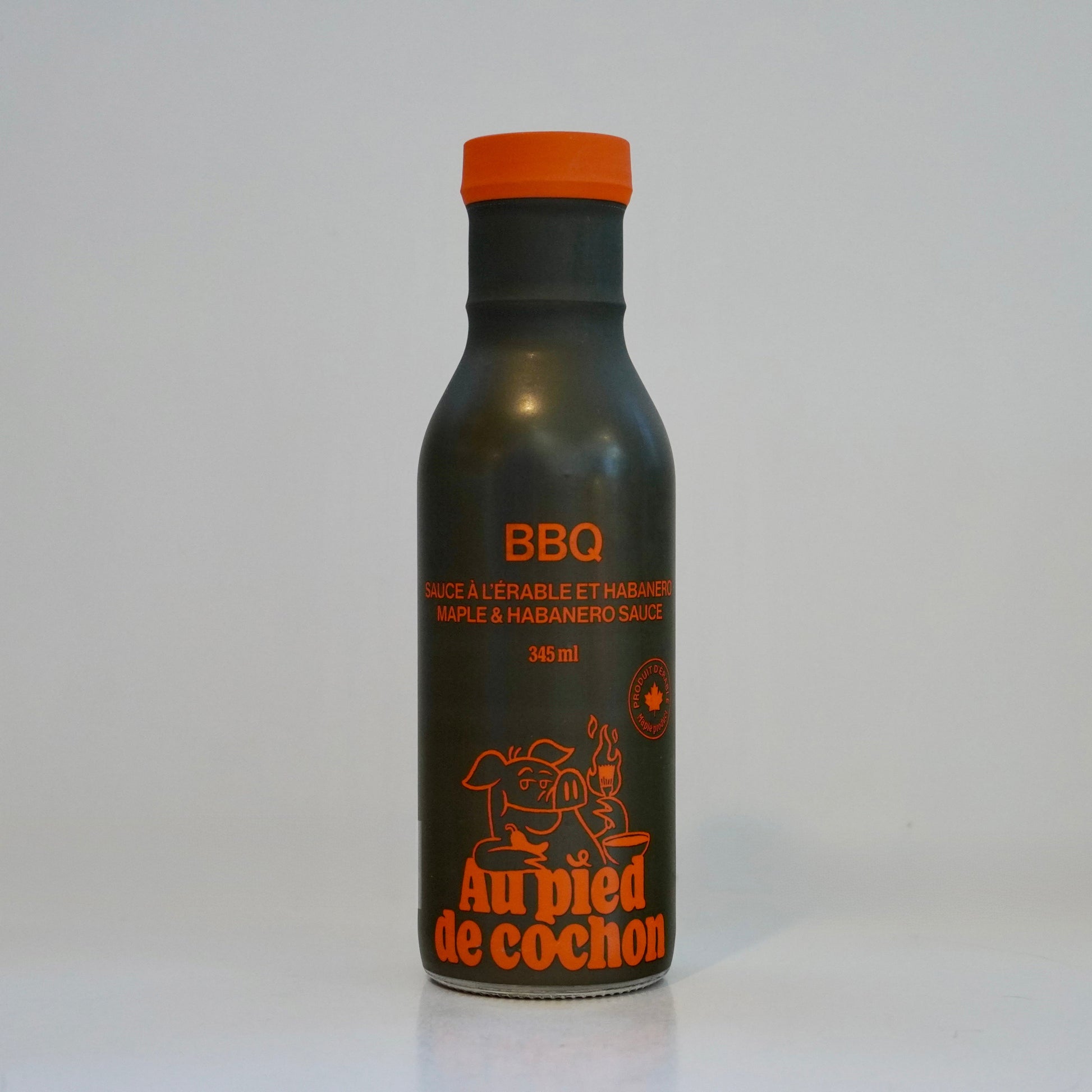 Bottle of Au Pied de Cochon BBQ sauce on a white background