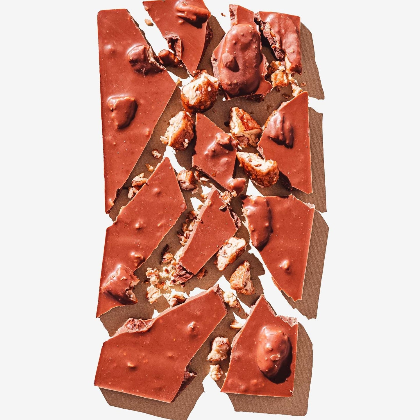 Broken chocolate bar with nuts on a white background