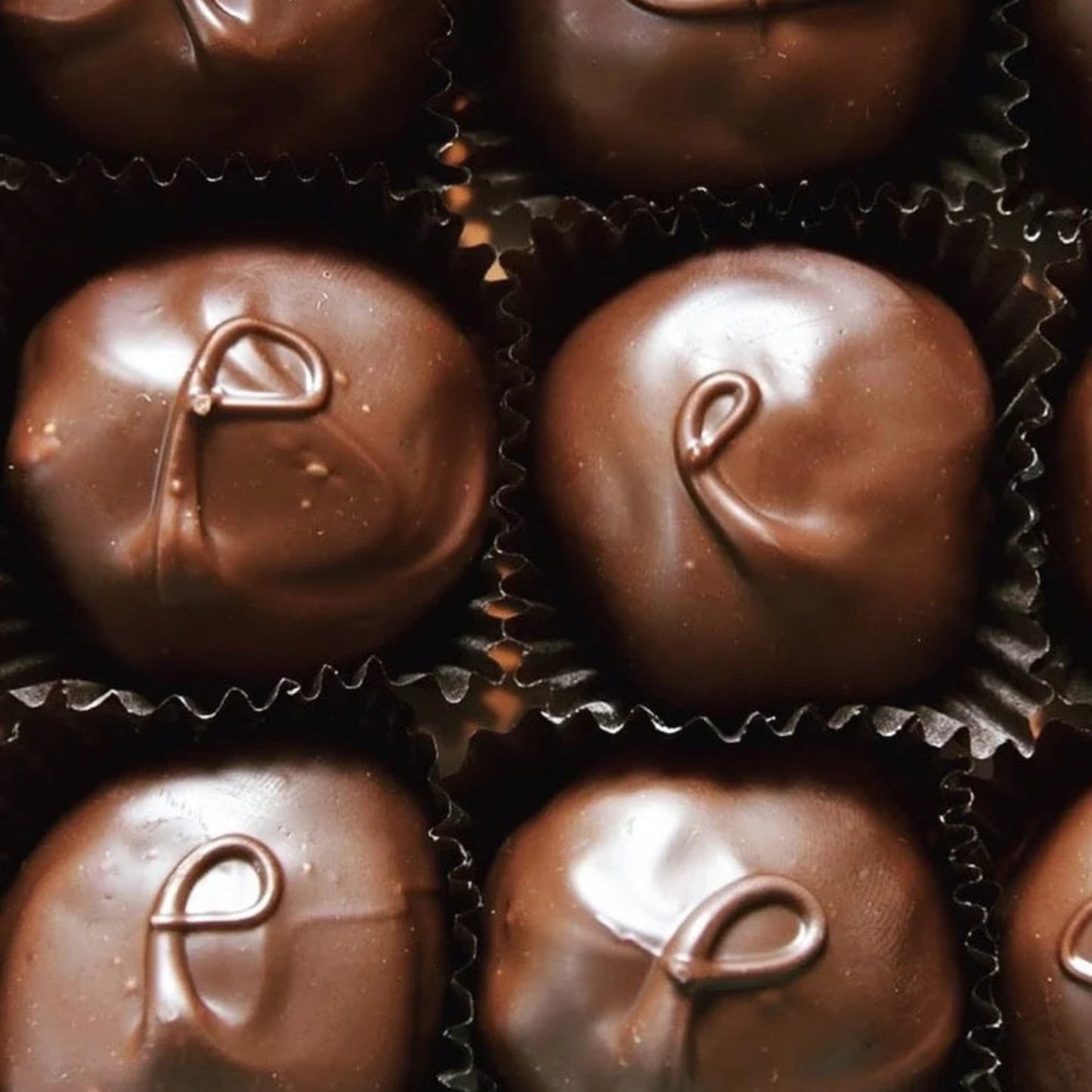 Close-up of chocolate candies with a logo on a grid