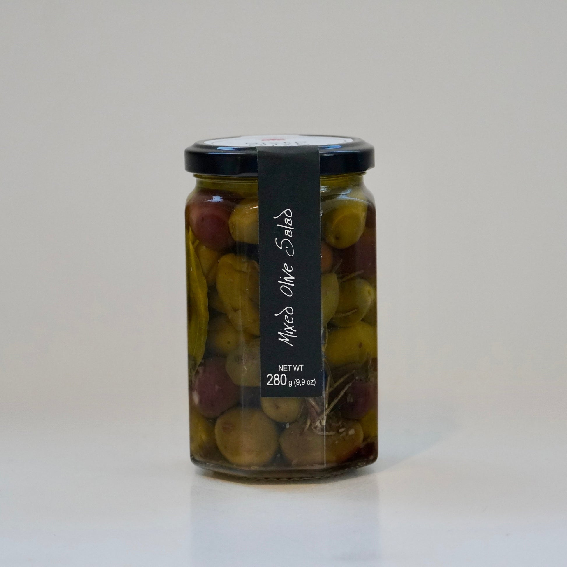 Jar of mixed olive salad with a black label on a white background