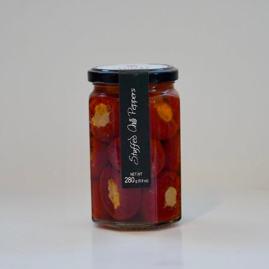 Jar of pickled peppers with a black label on a white background