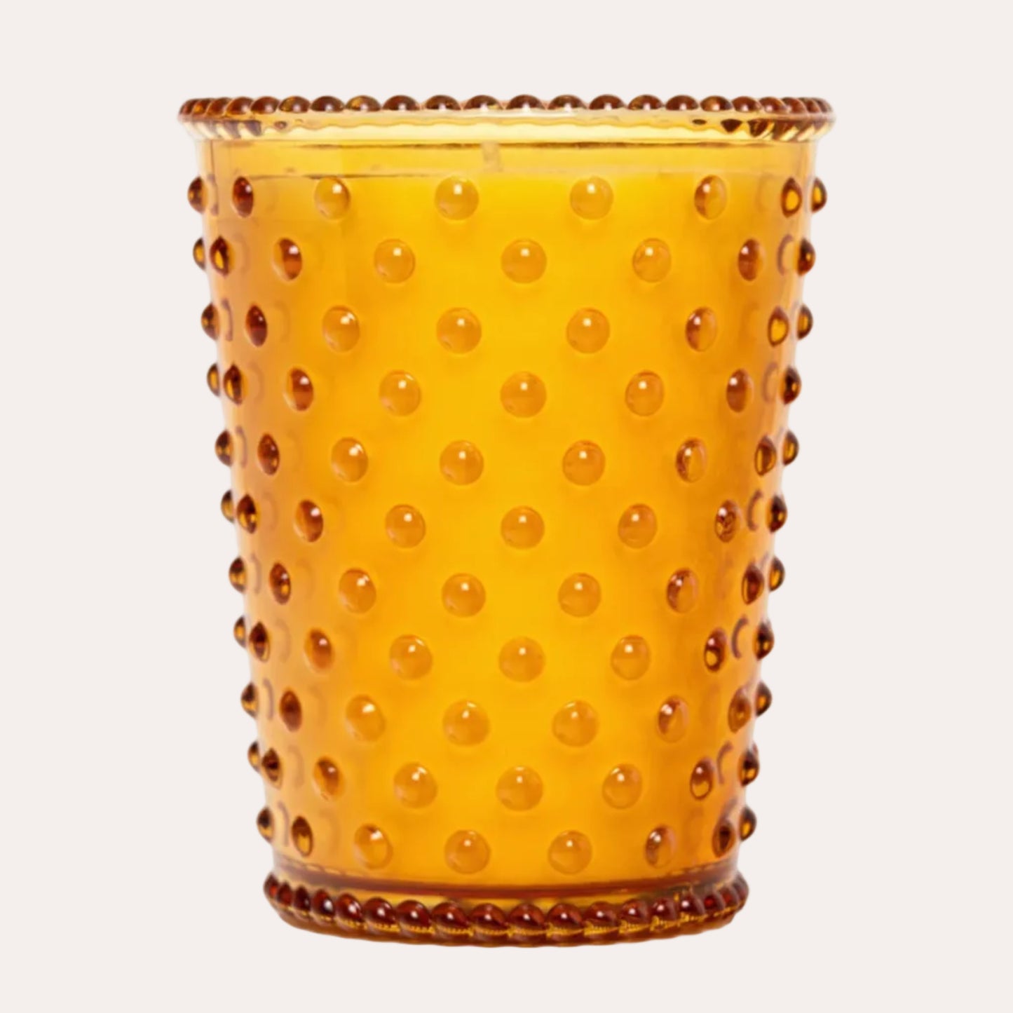 An amber glass candle holder with a textured hobnail pattern and a beaded rim, shown on a solid white background.