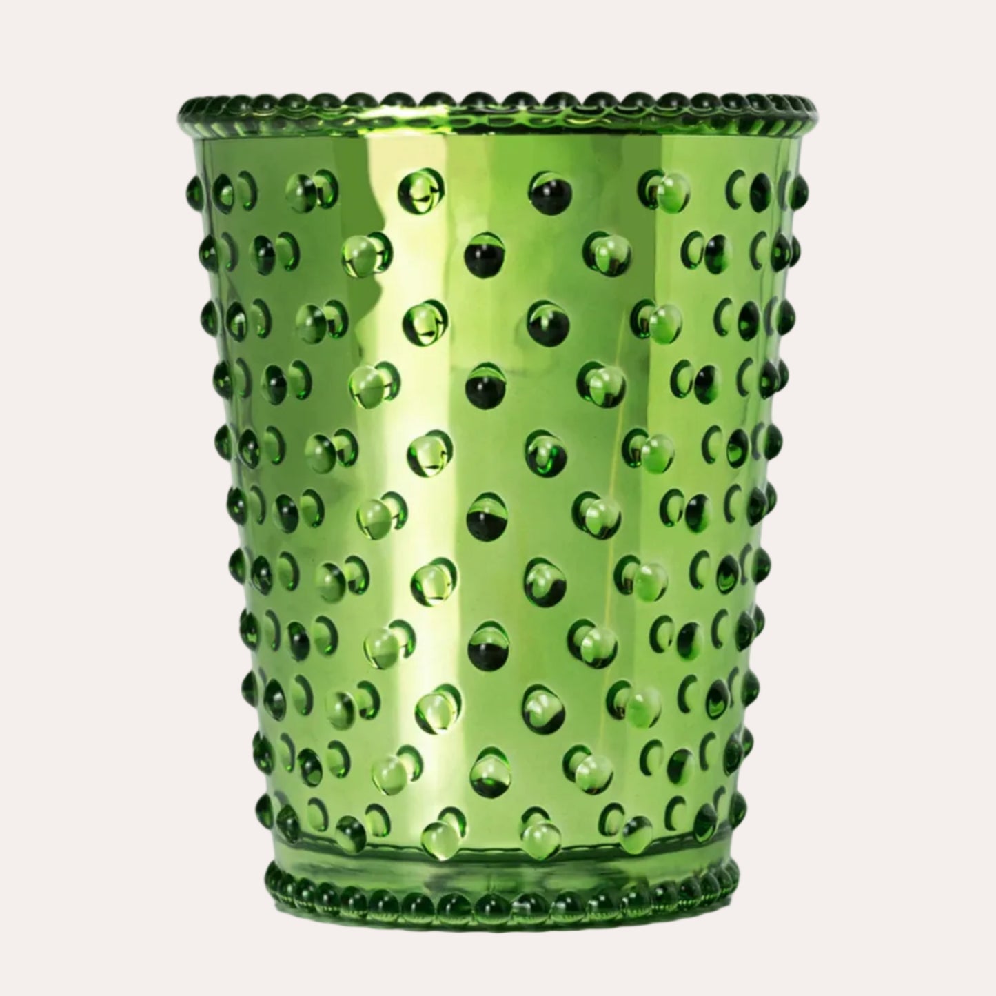 A green glass cup with a textured, dimpled hobnail pattern and a scalloped rim, shown on a solid white background.