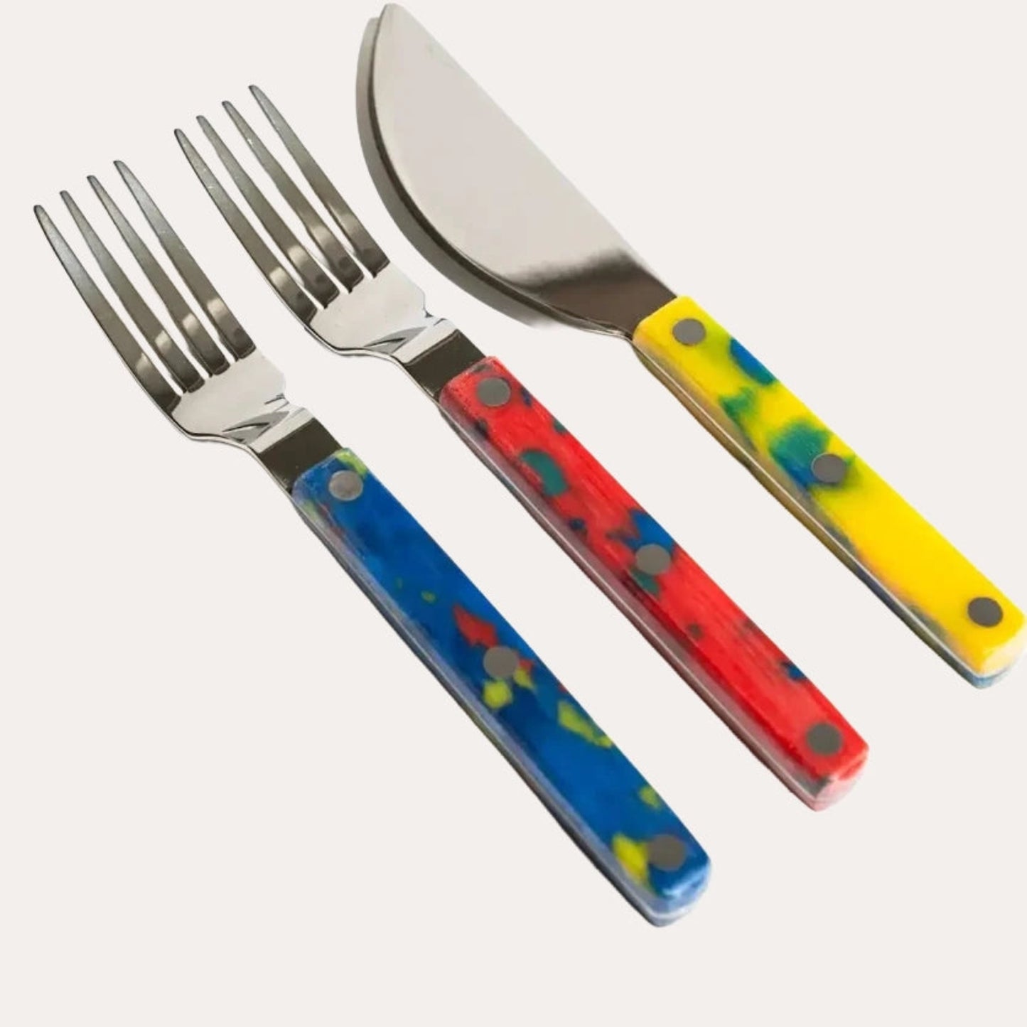 Set of colorful cutlery with blue, red, and yellow handles on a white background