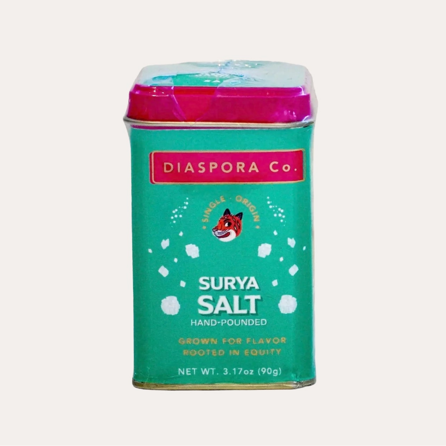 Teal canister of Surya Salt with pink lid on a white background
