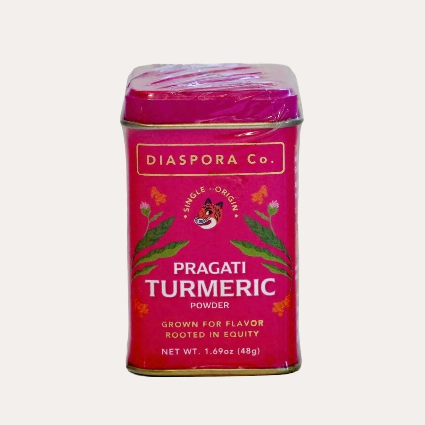 Pink canister of Pragati Turmeric powder by Diaspora Co. on a white background