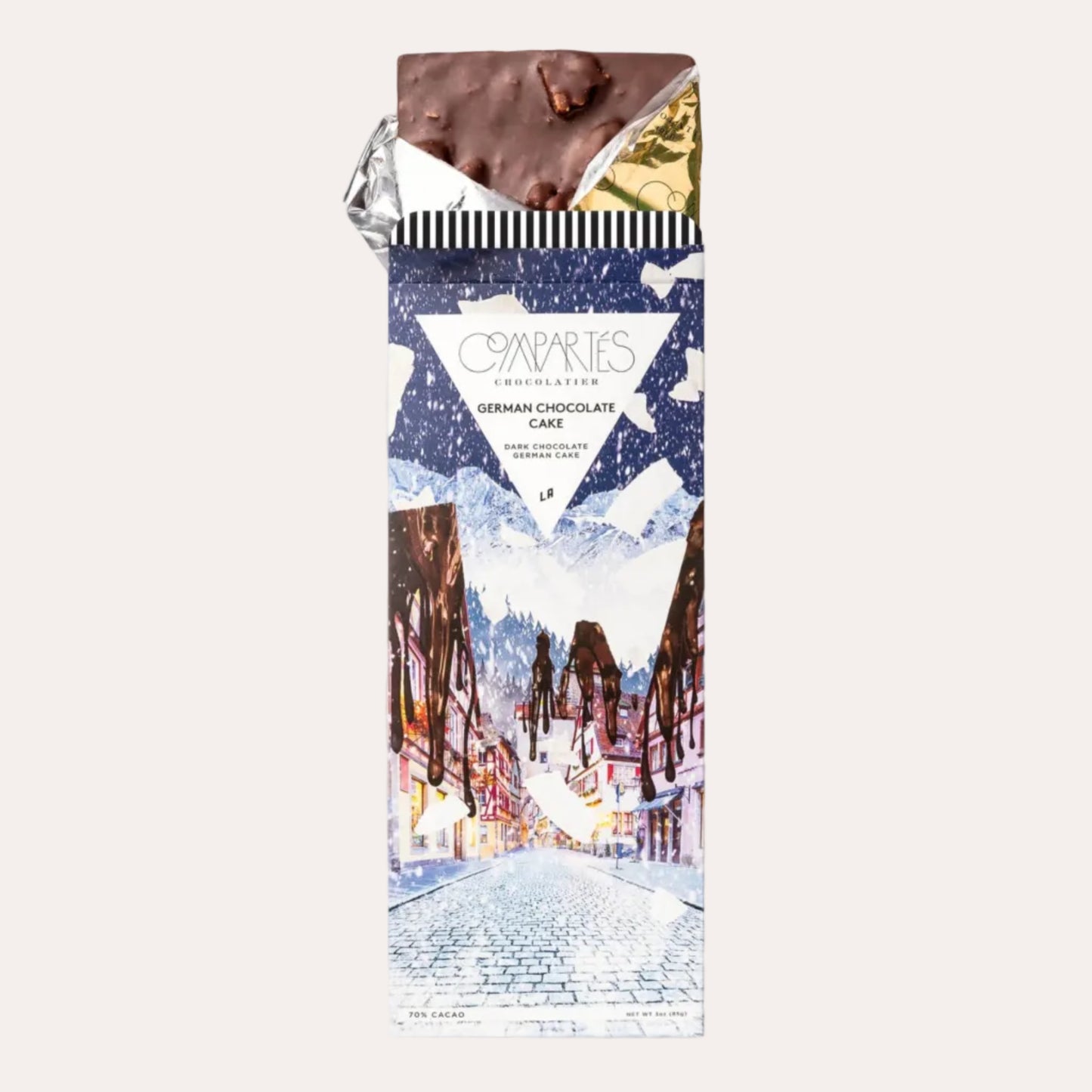 Chocolate bar with decorative packaging featuring a snowy village scene on a white background