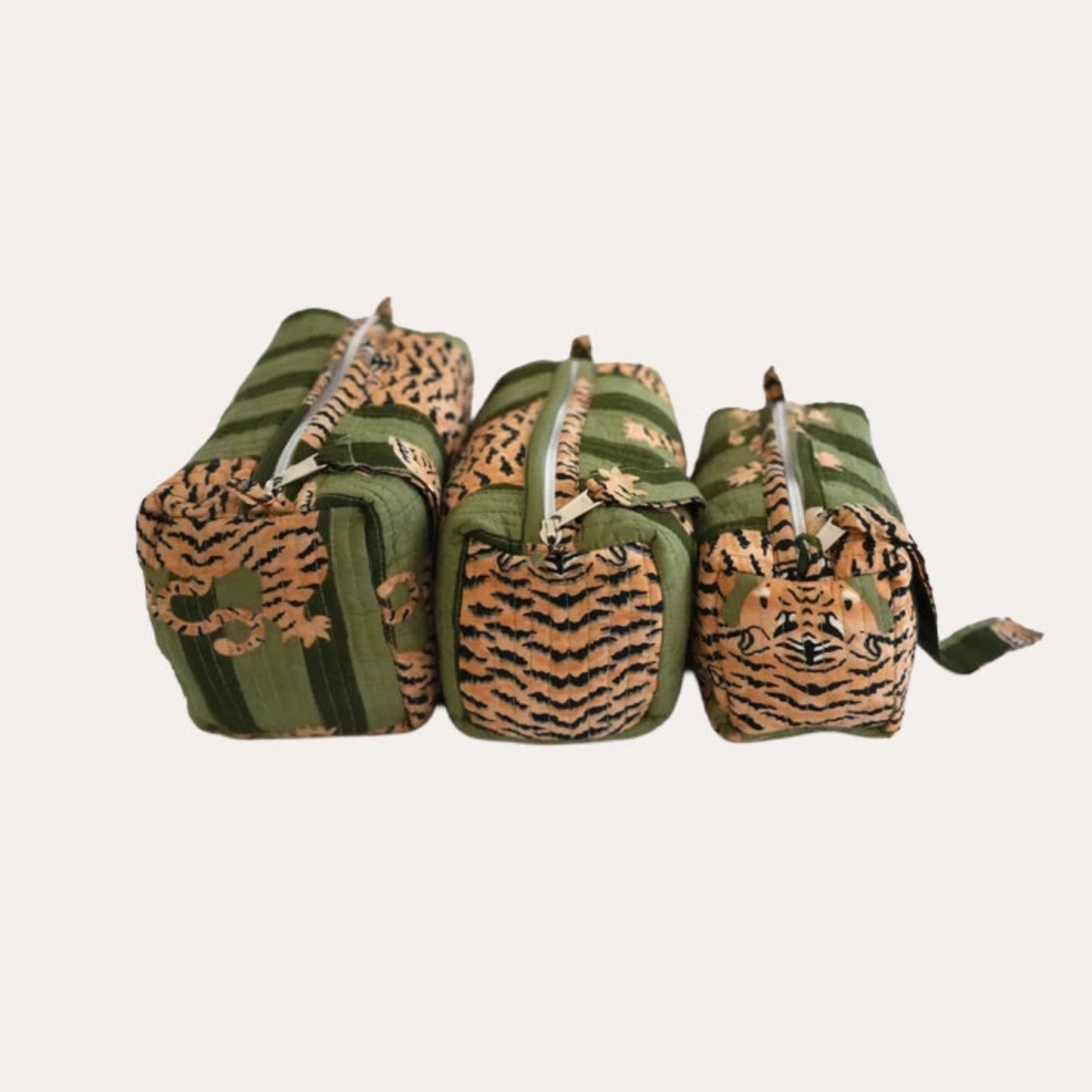 Three green and brown patterned bags with tiger face designs on a white background
