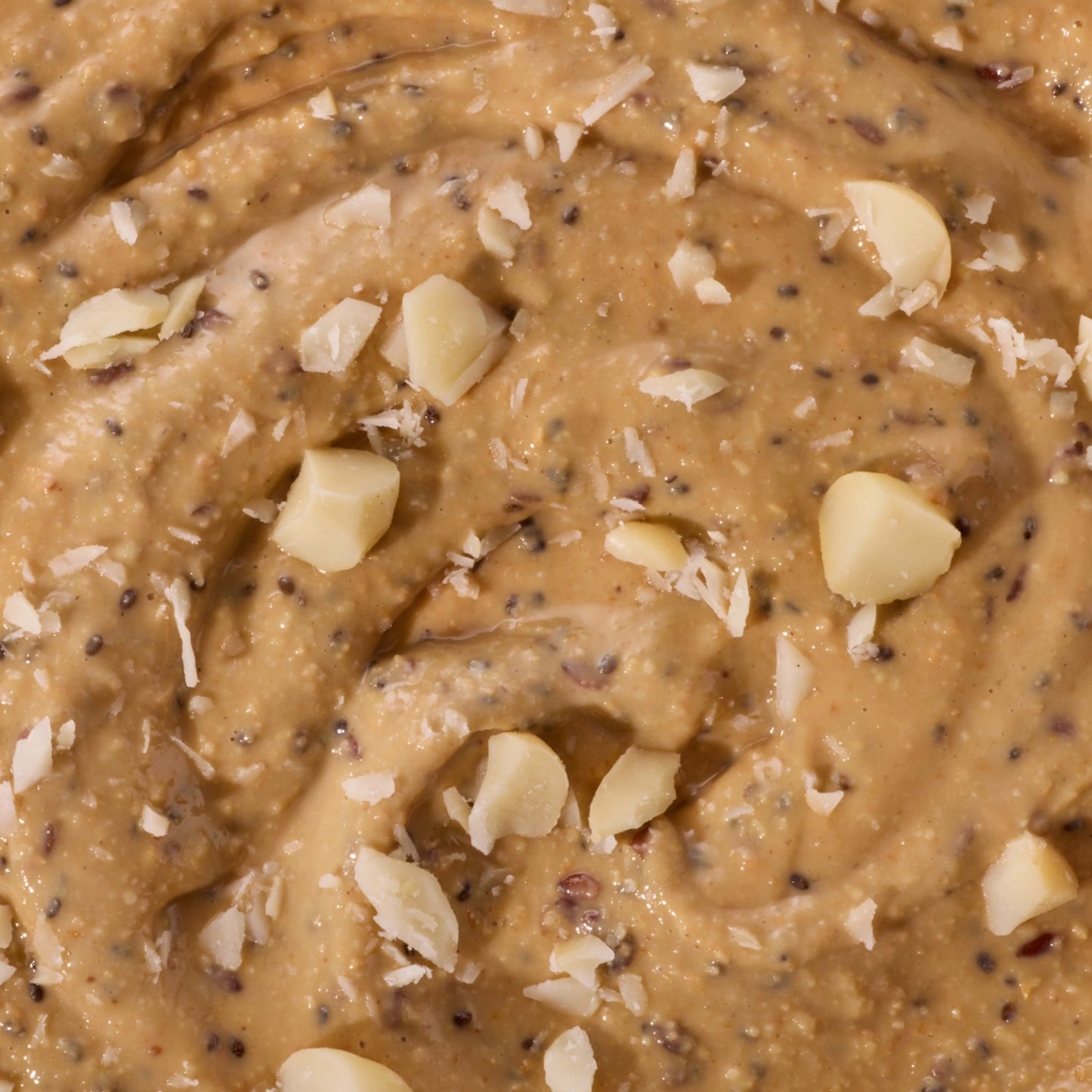 Close-up of a creamy peanut butter mixture with visible nuts and seeds.