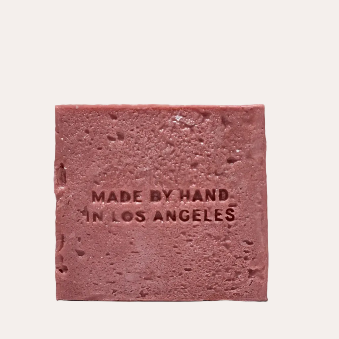 Pink square bar of soap with 'Made by Hand in Los Angeles' text on a white background