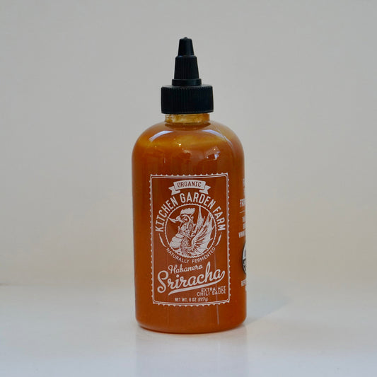 Bottle of Kettle Garden Farm Sriracha sauce on a white background