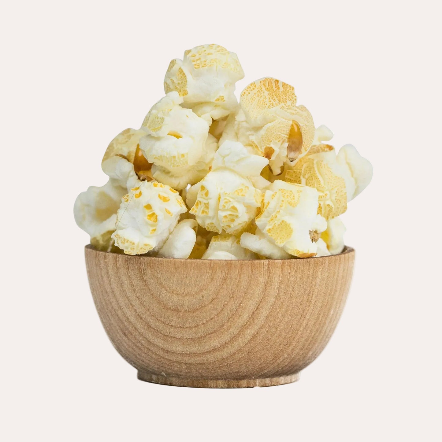 Wooden bowl filled with popcorn on a white background