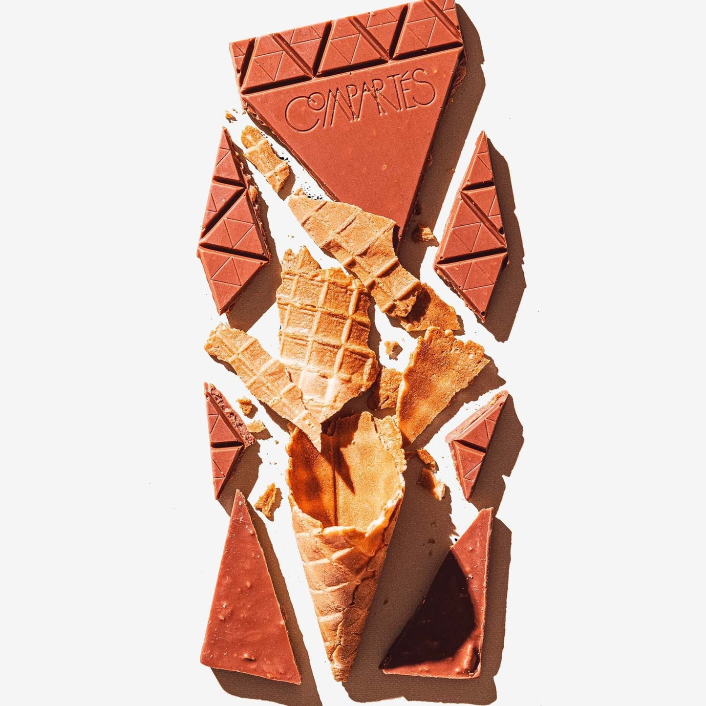 Broken chocolate bar with a waffle cone on a white background