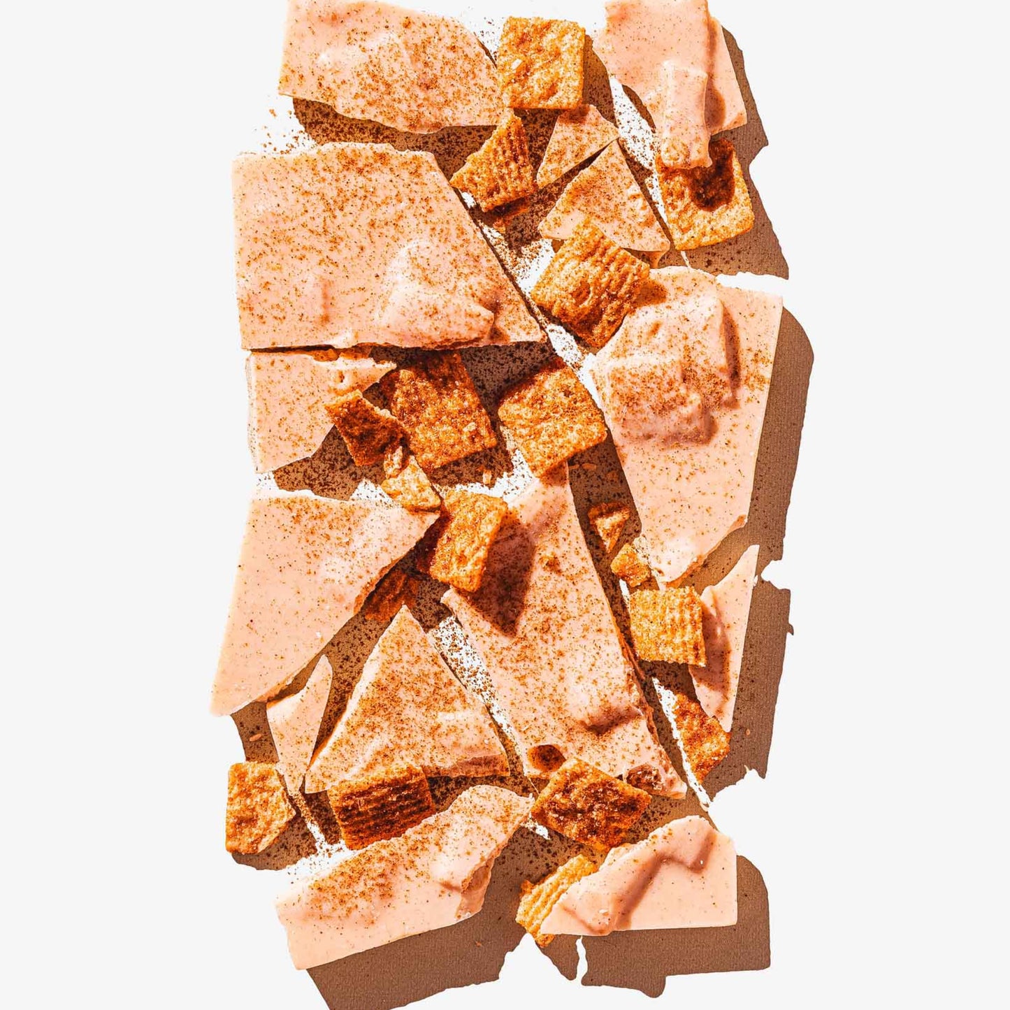 Broken pieces of a brown snack on a white background