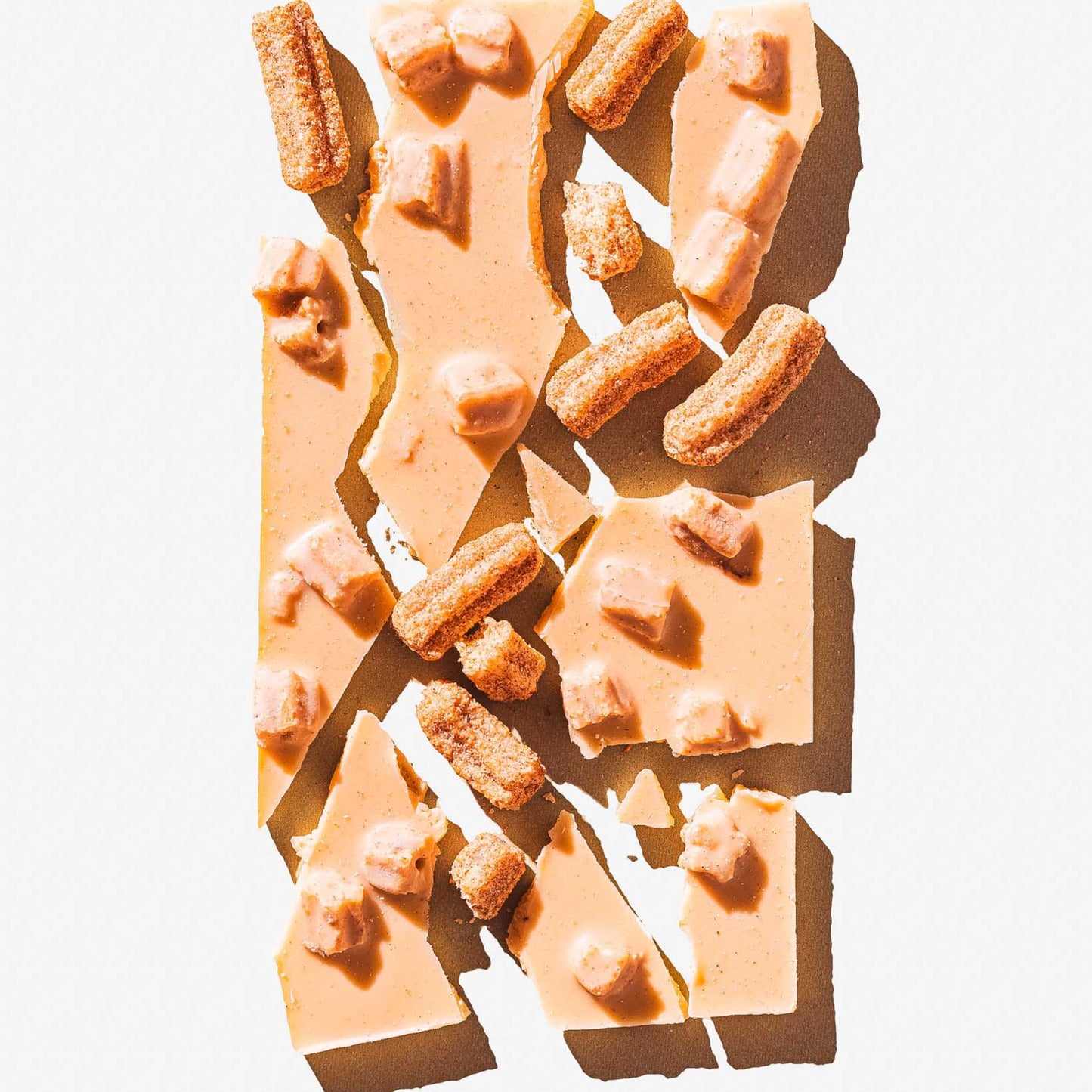 Broken pieces of chocolate with nuts on a light background