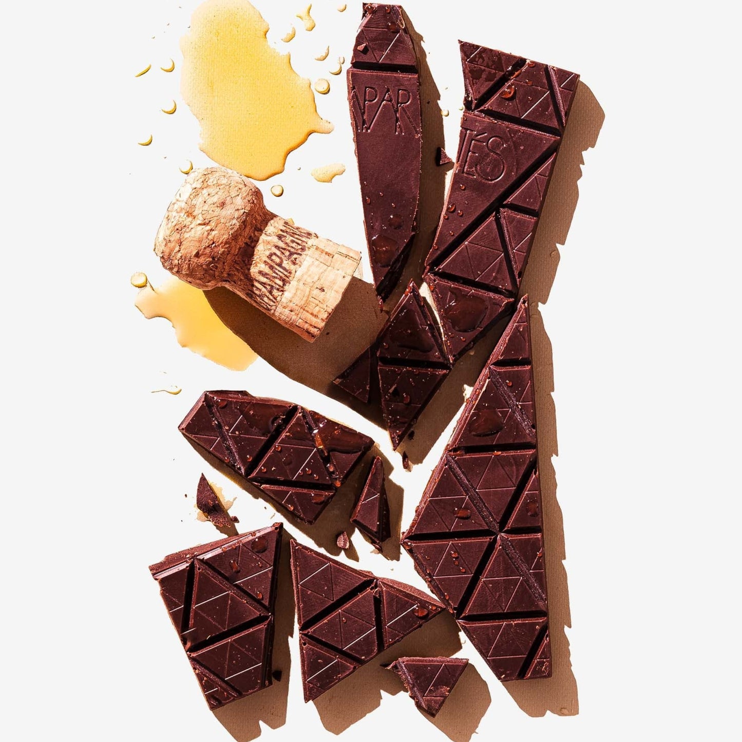 Broken chocolate bars with a small piece of nougat on a light background