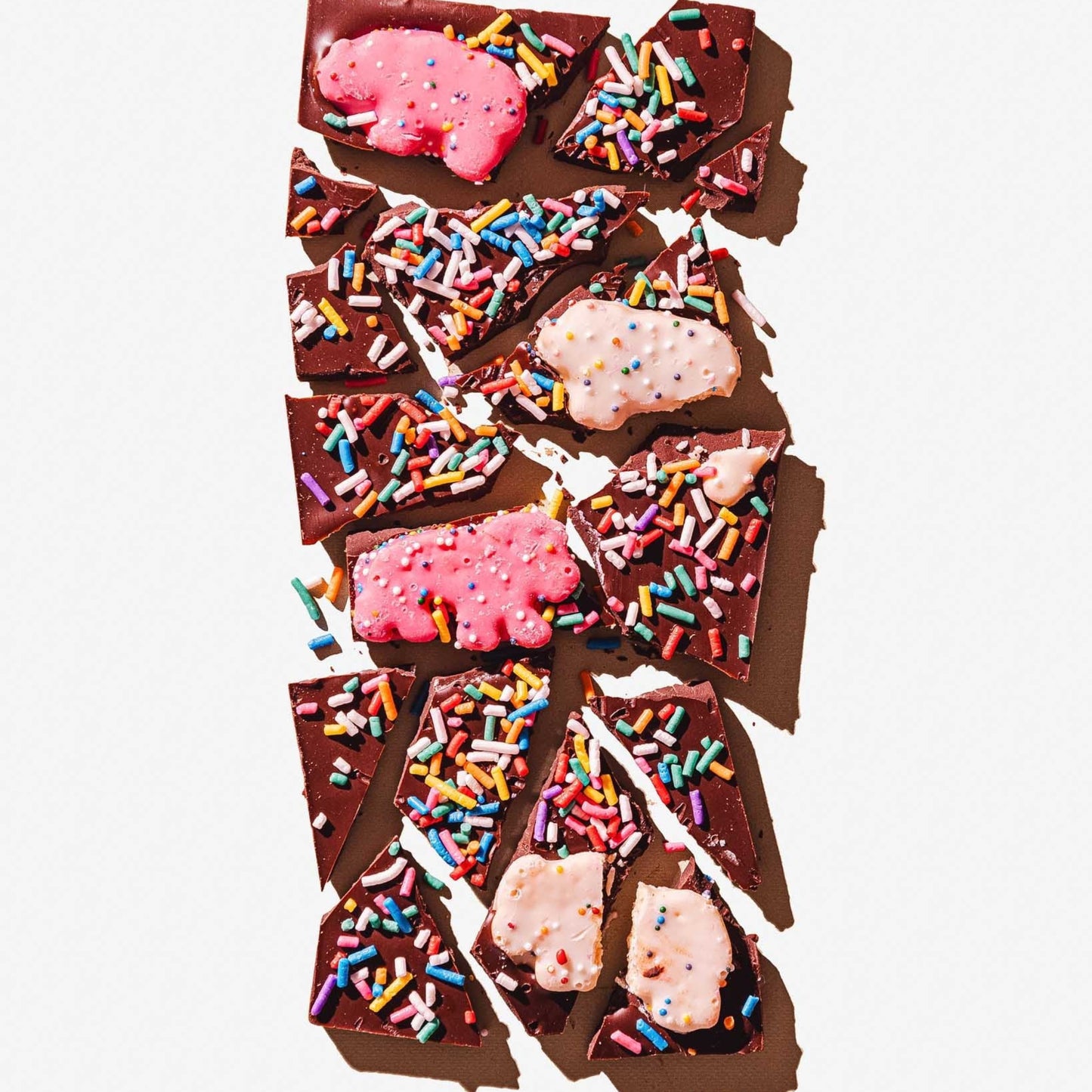Chocolate bars with pink candy and colorful sprinkles on a white background