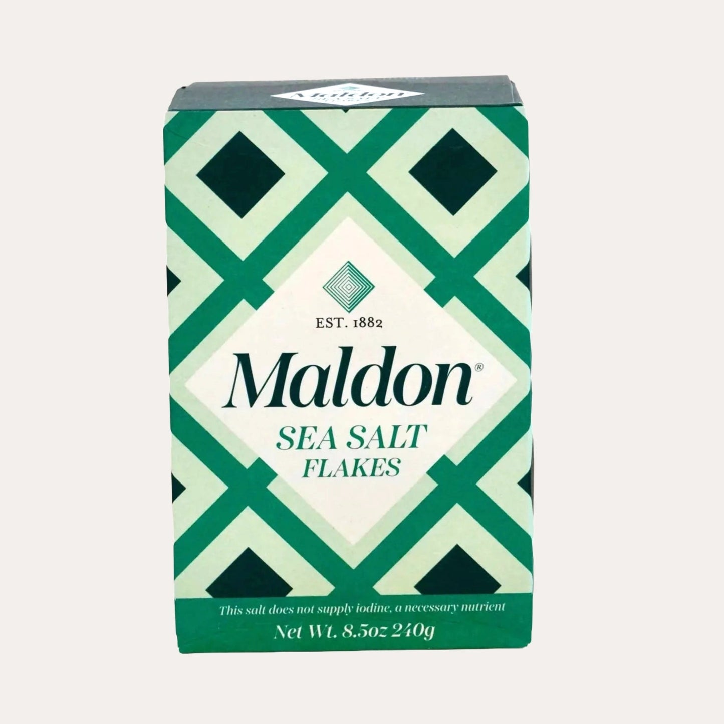 Maldon sea salt flakes packaging with green and white geometric design on a light gray background