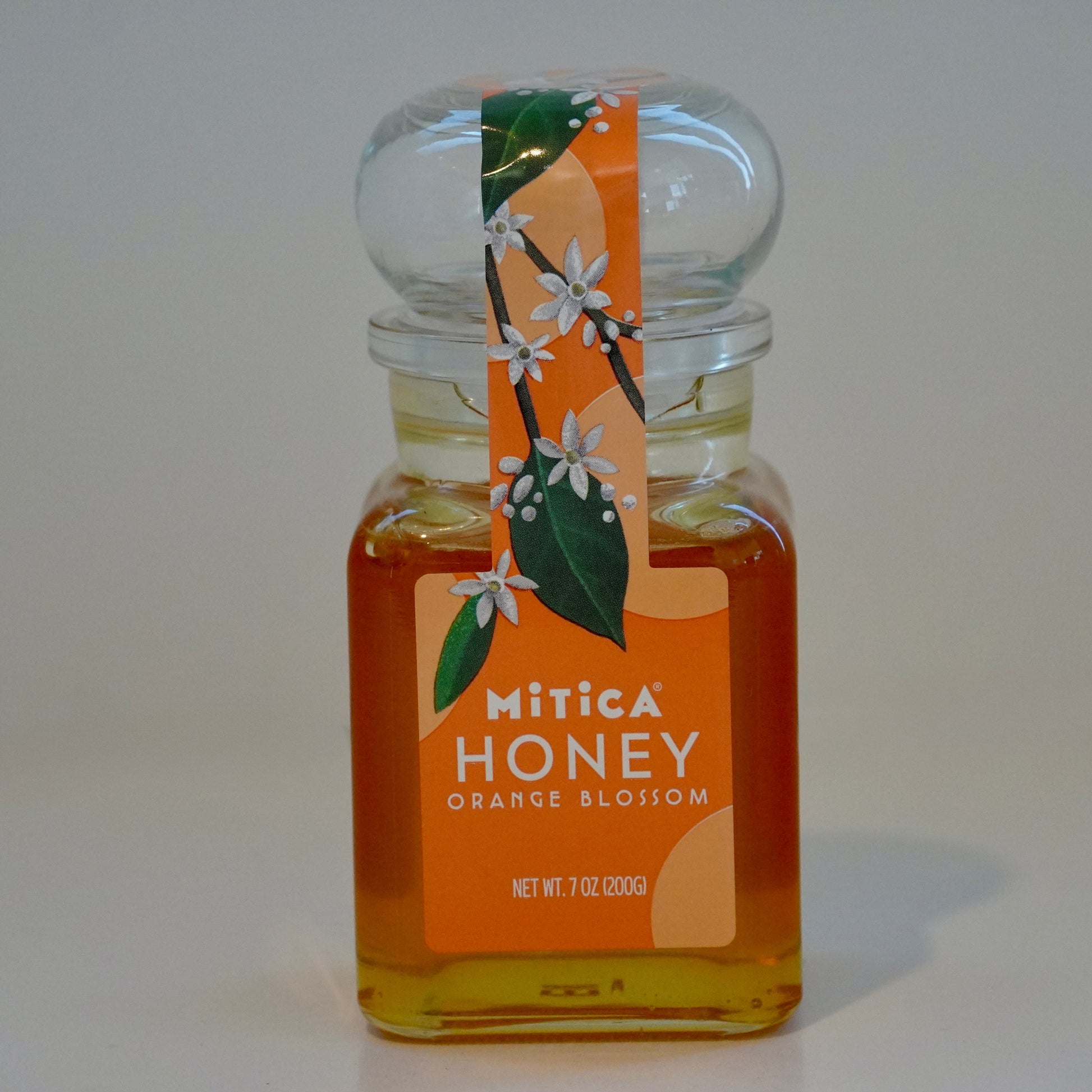 Bottle of Mitica Honey with orange blossom design on a white background