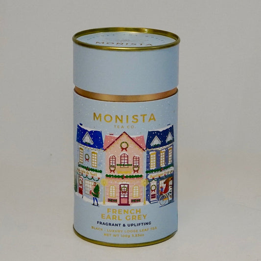 Small cylindrical tin with decorative design on a plain background