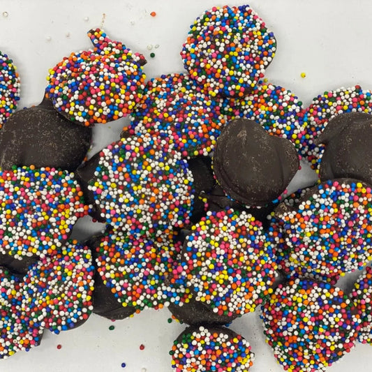 Chocolate truffles with colorful sprinkles on a white background