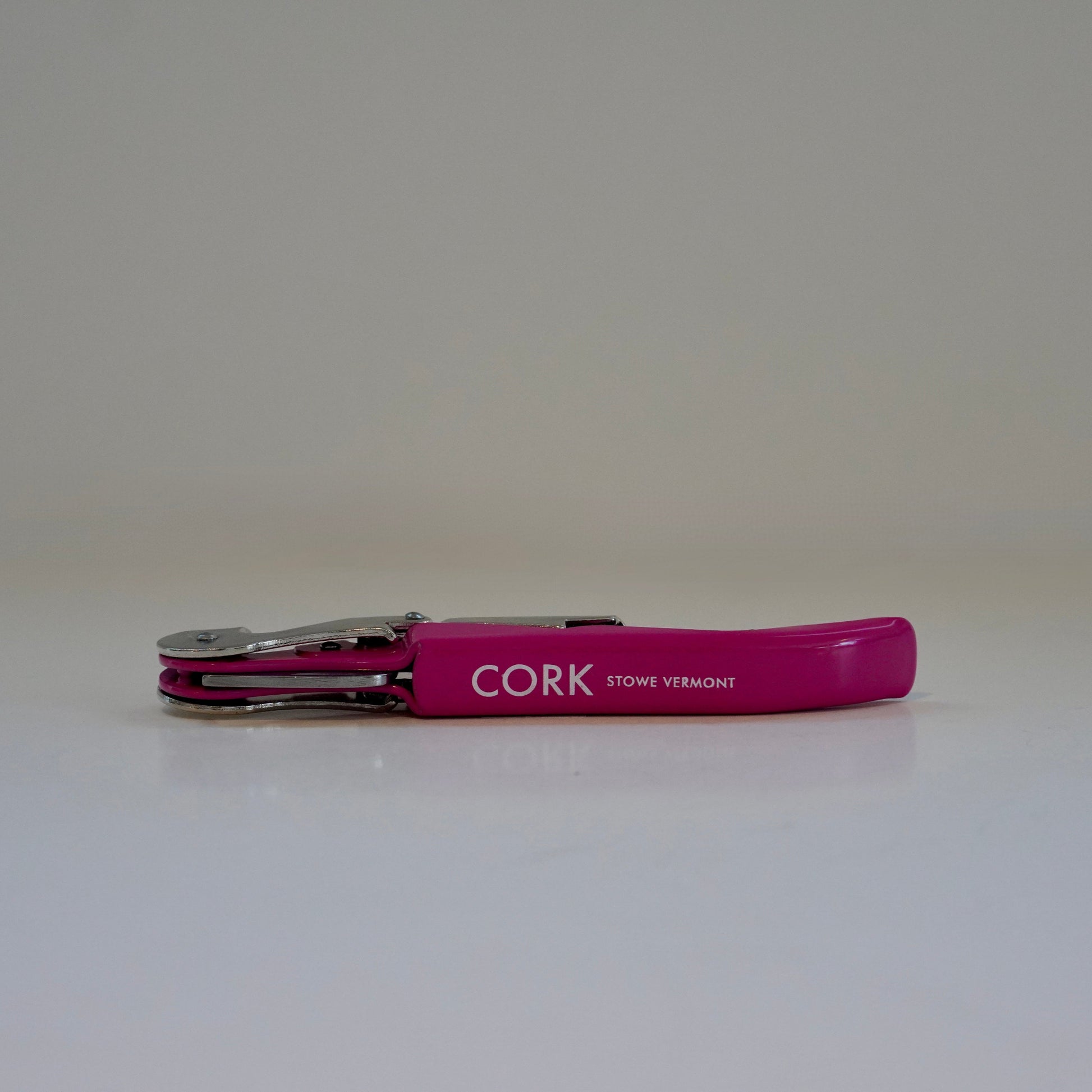 Pink bottle opener with 'CORK' branding on a white background