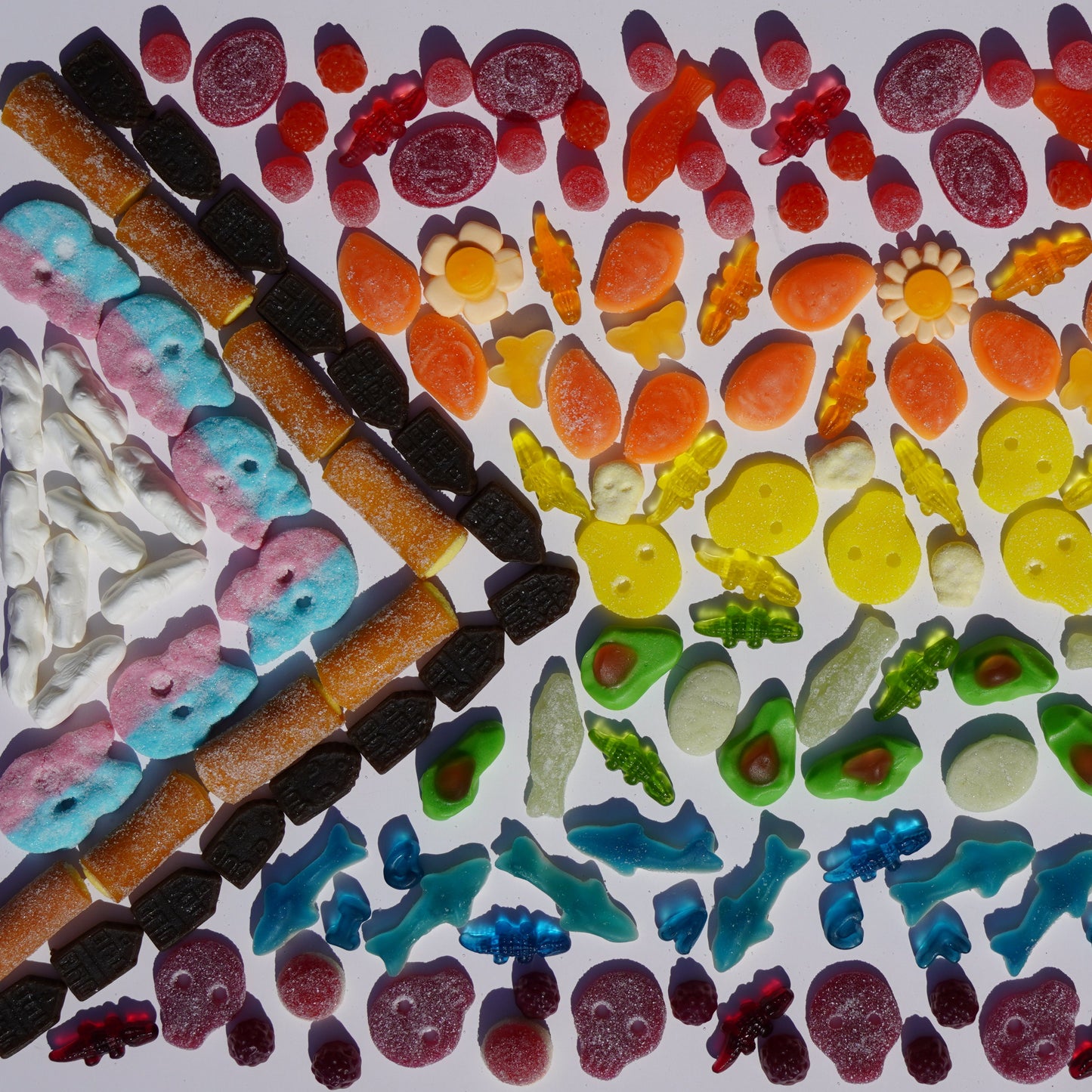 Colorful gummy candy arranged in a pattern on a white background