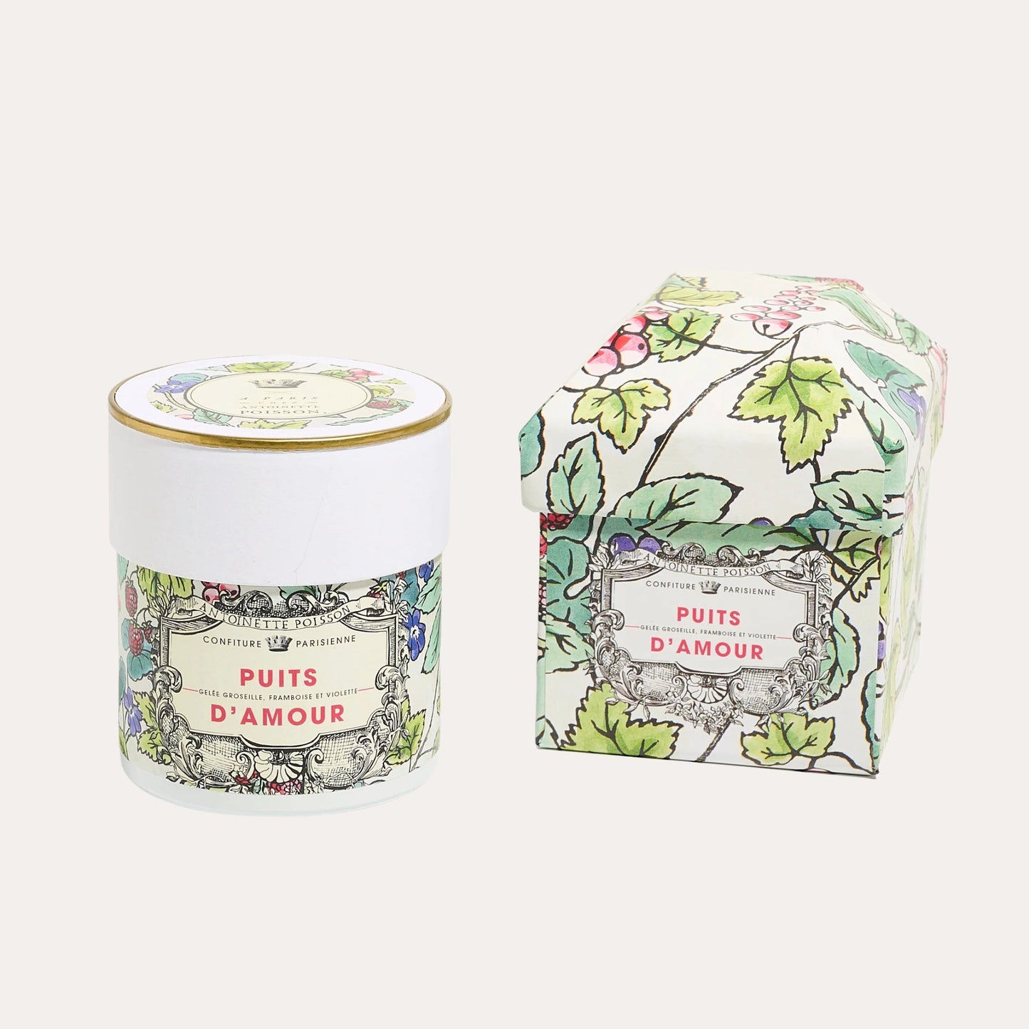 Candle and packaging with floral design and 'Puits d'Amour' text on a white background