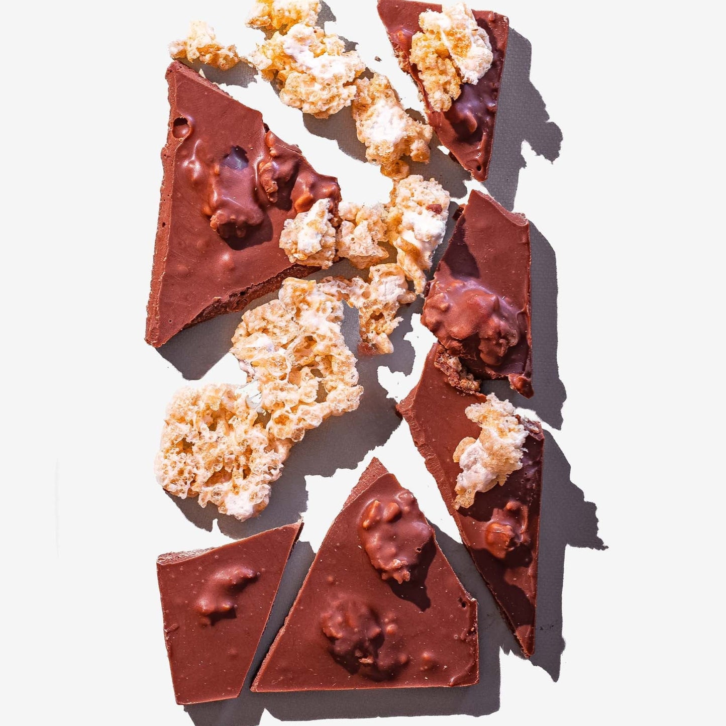 Chocolate pieces with popcorn on a white background