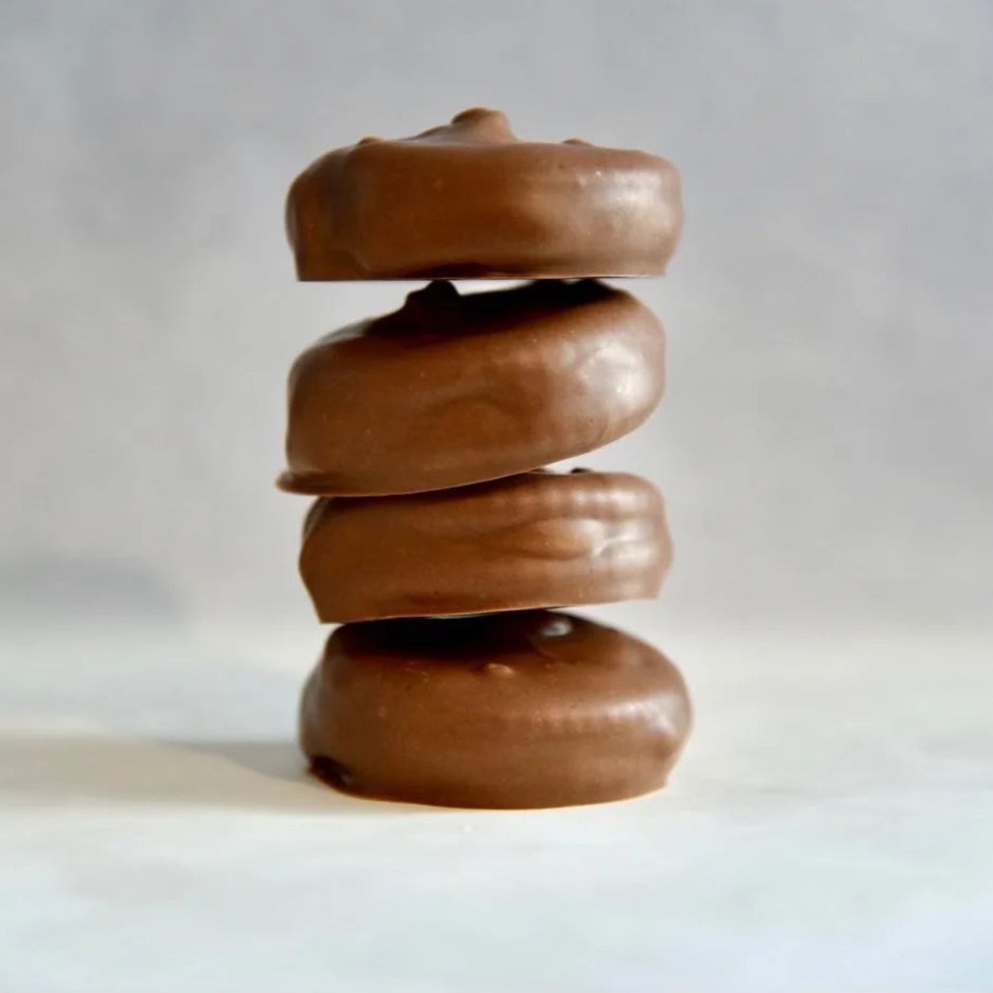 Stack of chocolate-covered donuts on a white background