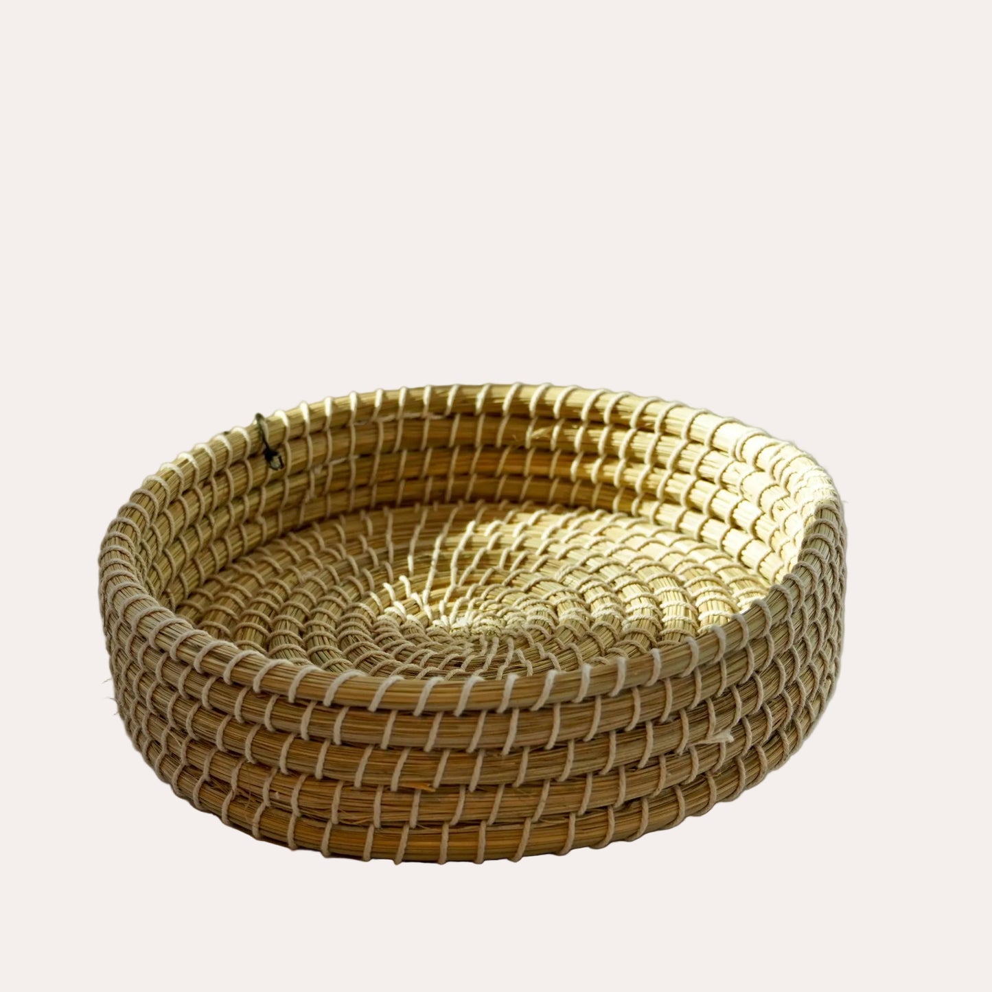 Woven basket on a white surface with a light gray background