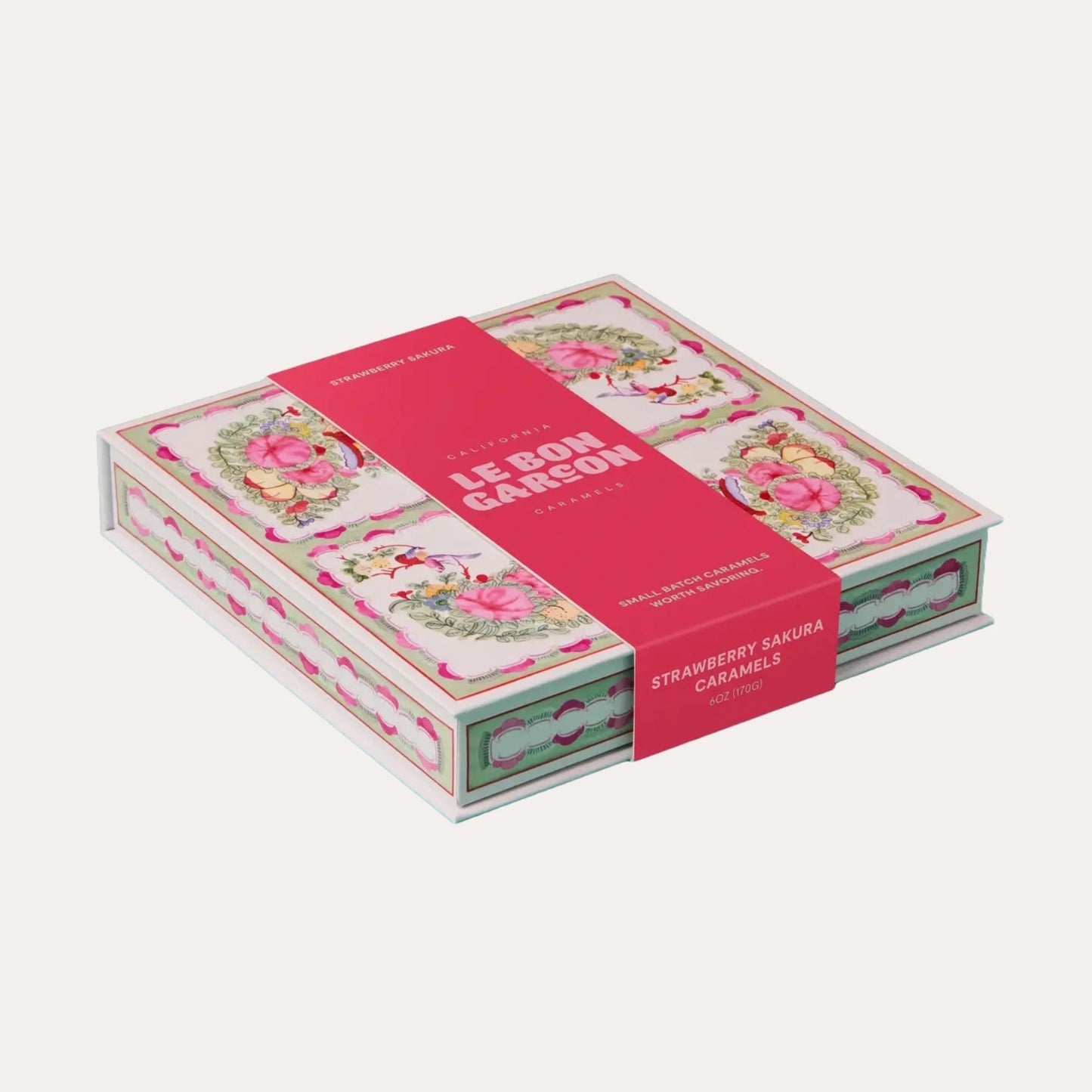 Box of strawberry sakura candies with floral design on a white background