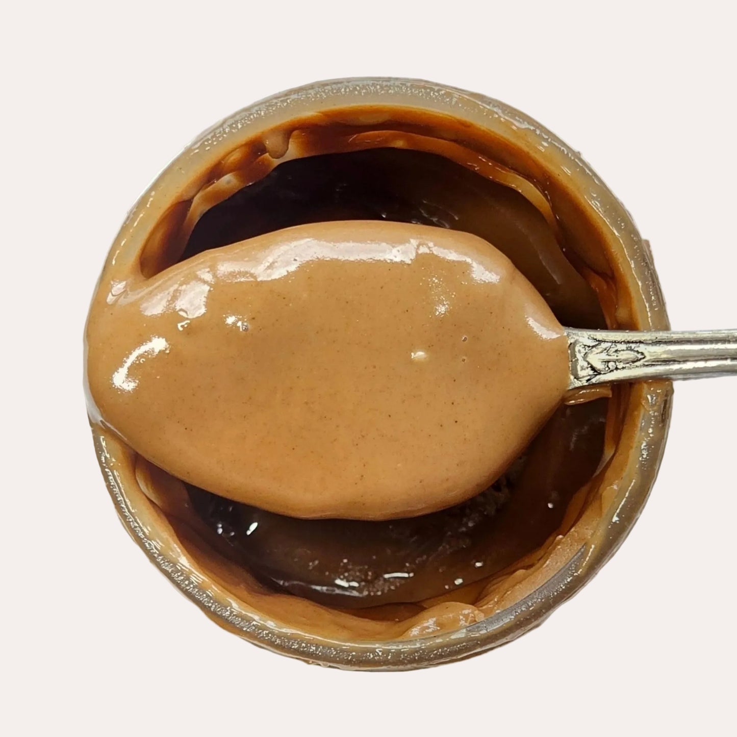 Jar of hazelnut spread with a spoonful on a white background
