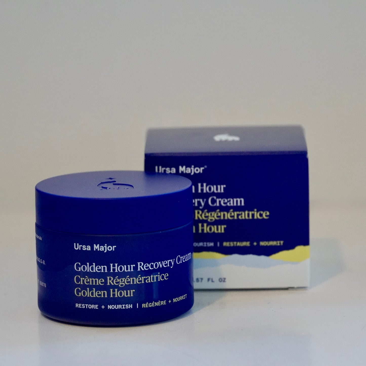 Blue jar and box of Ursa Major Golden Hour Recovery Cream on a white background