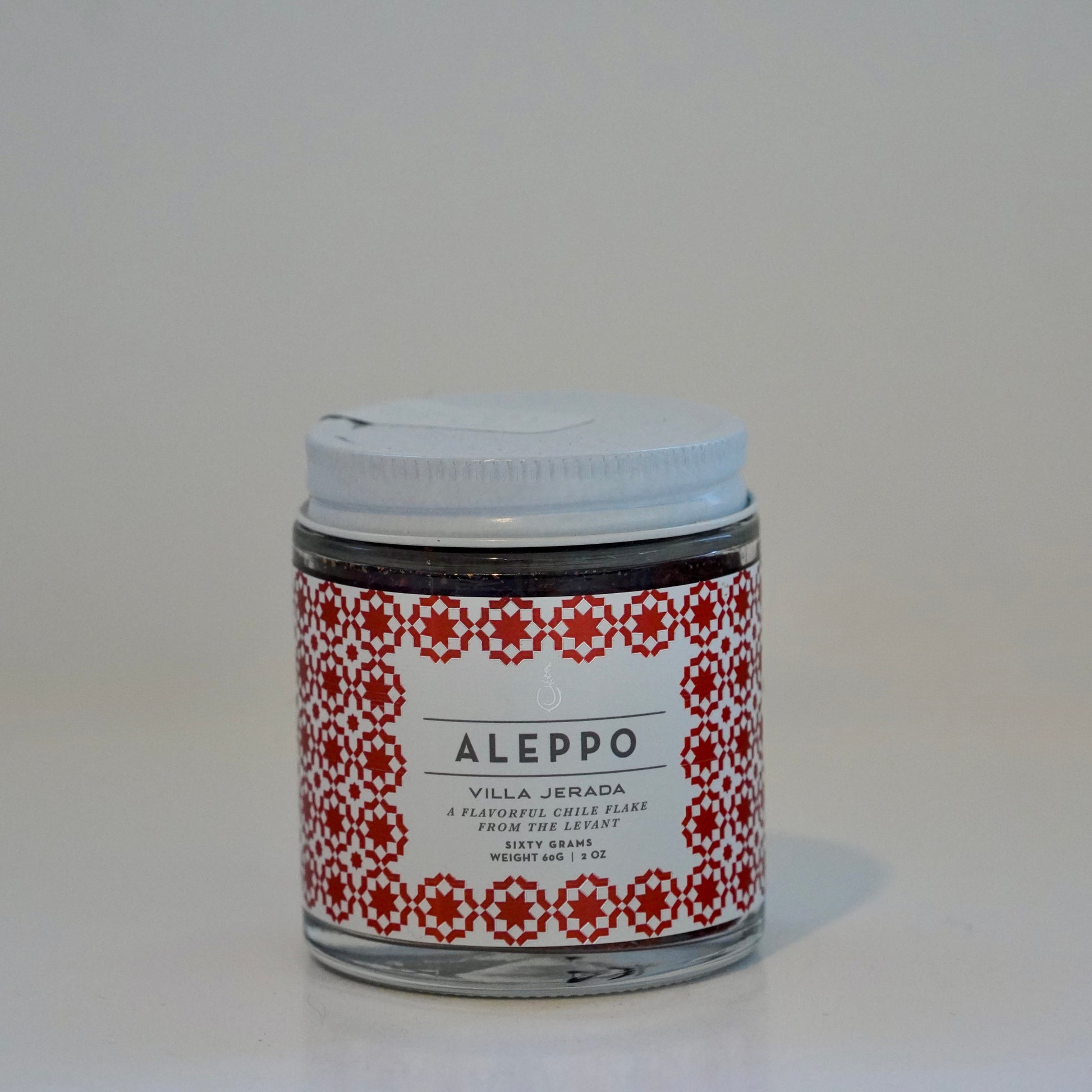 Jar of Aleppo product with a decorative label on a white background