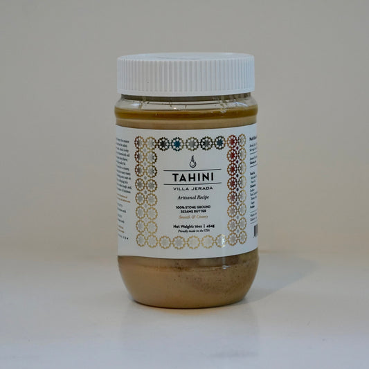 Jar of tahini with a white label on a light background