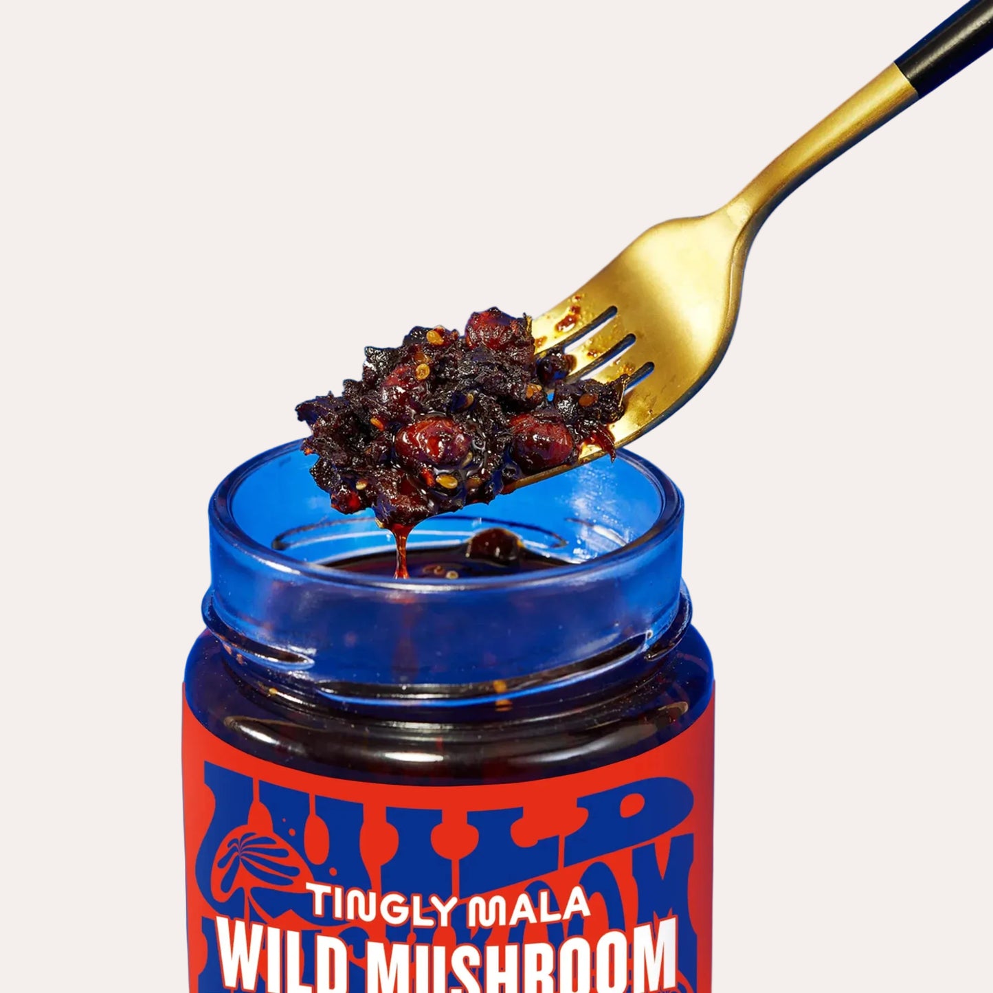 Jar of 'Wild Tingly Mala Wild Mushroom' with a gold fork on a blue background