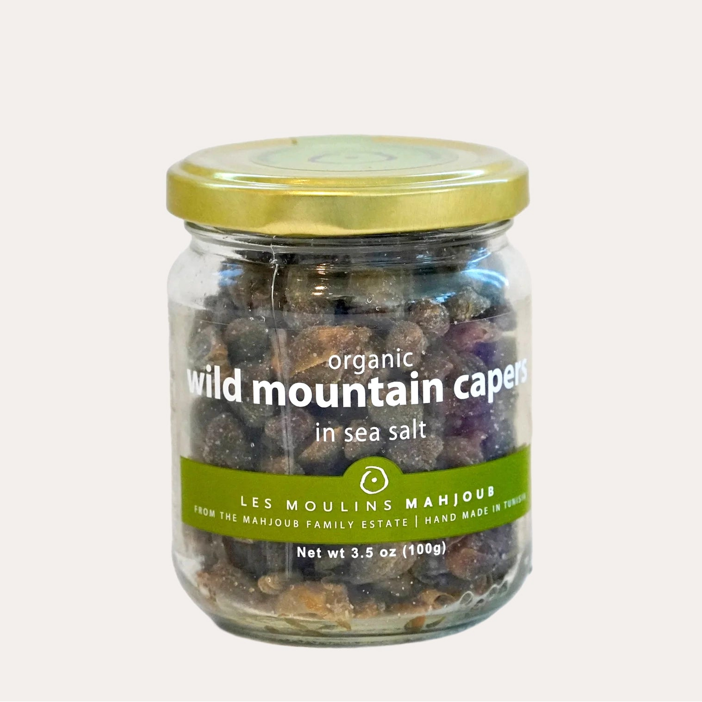 Jar of organic wild mountain capers in sea salt on a white background