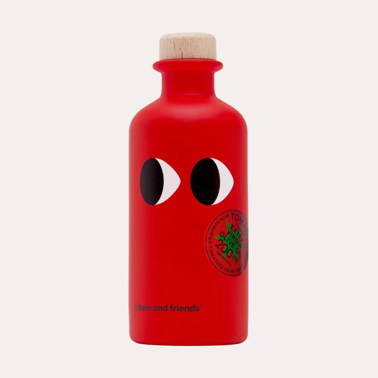 A bright red bottle with a light wood cork stopper, featuring the iconic black-and-white eyes and a green circular logo from Comme des Garçons Tokyo, with 'Tokyo and friends' printed near the bottom, set against a solid off-white background.