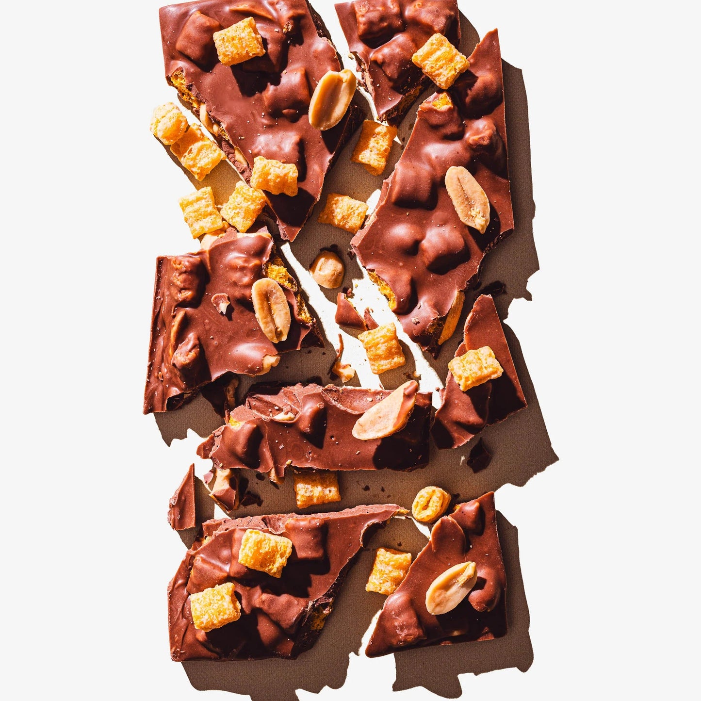 Chocolate bar with nuts and caramel pieces on a white background