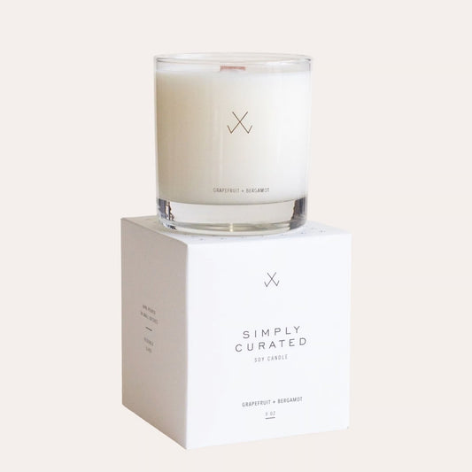 Glass candle with a white label on a white box labeled 'Simply Curated' against a white background